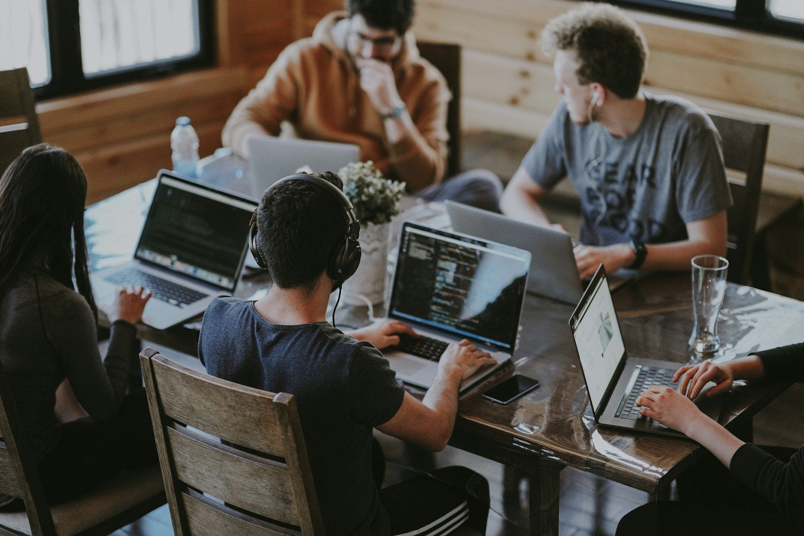 The MariaCS team building automation tools together around a table of laptops
